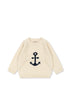 Beige sweater with a navy anchor design on a white background