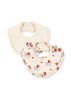 Two baby bibs with frill detailing. One is solid beige, and the other features a floral pattern with red and green colors.