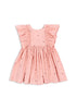 A pink dress with frill sleeves and bow details, made of organic cotton, displayed against a white background.
