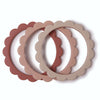 Set of three scalloped-edge silicone rings in pink and beige on a white background