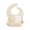 Beige baby bib with gold patterns on a white background