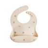 Beige silicone bib with rainbow pattern on a white background