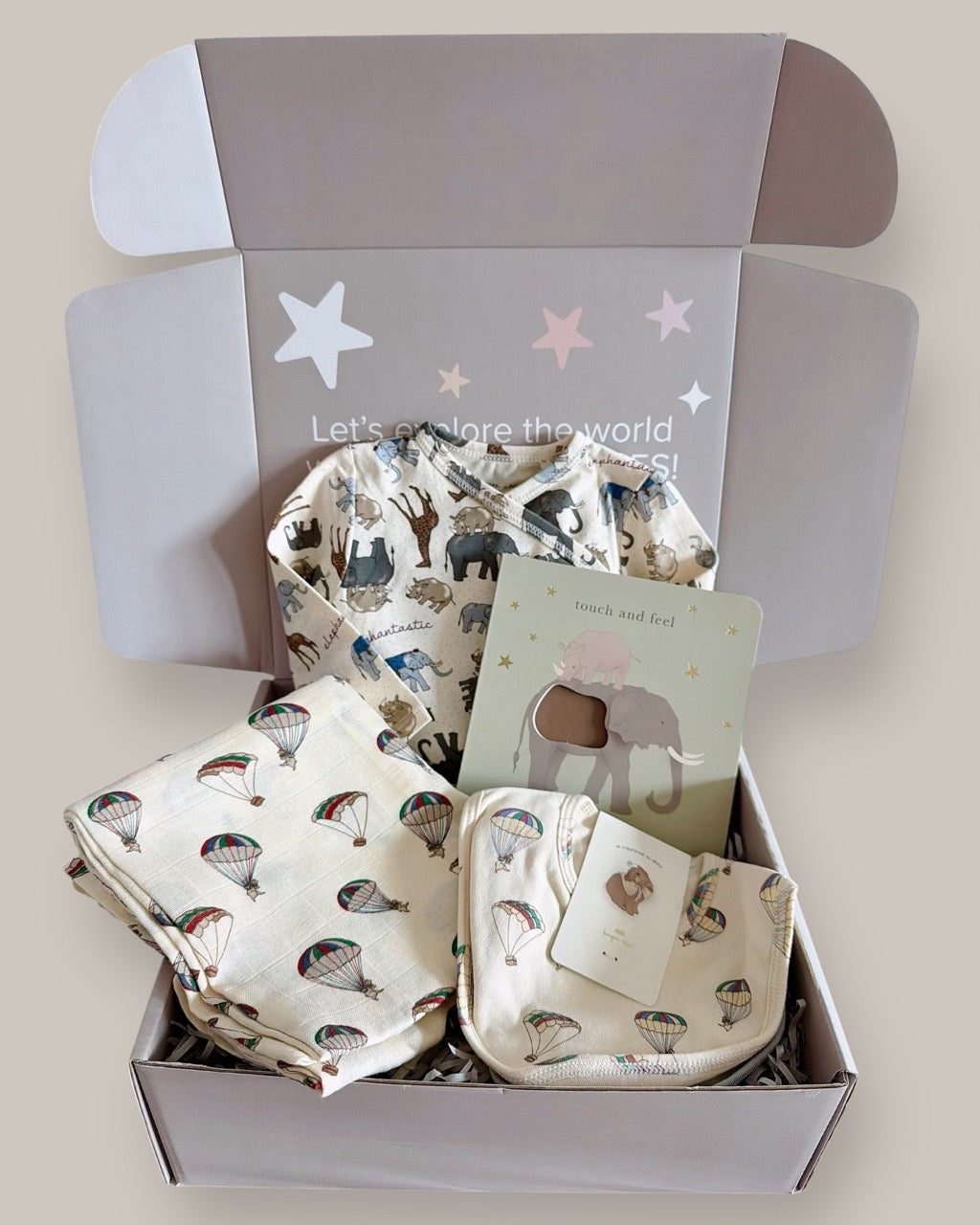 Baby gift set with blankets and toys in a box on a light background