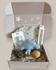 Baby gift box with toys and clothing on a light background