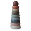 A tower of seven colorfully stacked rings, with a brown top ring and pastel shades below, placed against a white background.