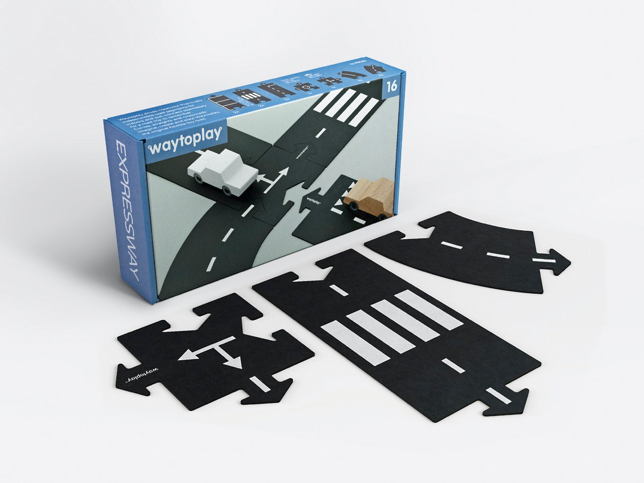 A flexible black road toy set by WAYTOPLAY, with various road pieces laid out, including straights, curves, an intersection, and a roundabout. The toy is designed for imaginative play and can be used inside or outside.